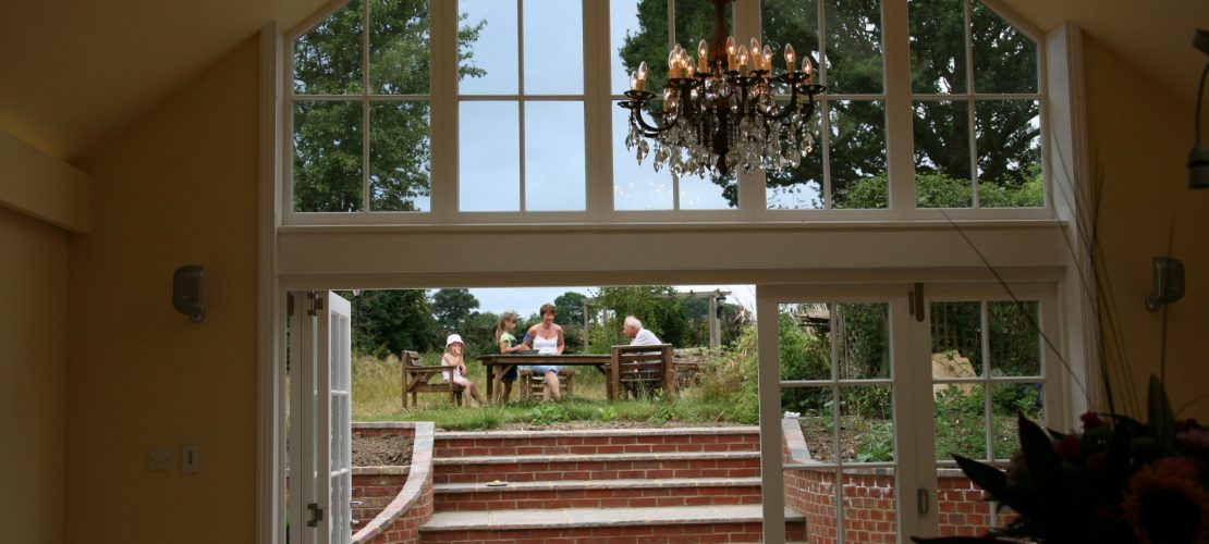 Bifold back doors showing stairs, garden and family eating